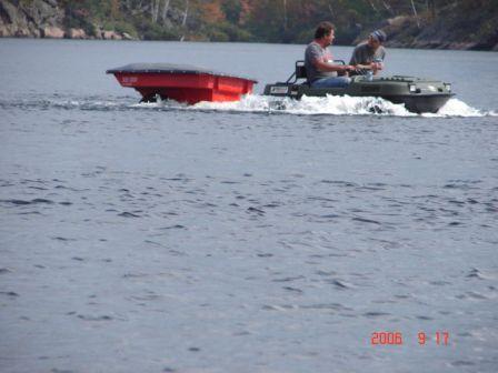 Bigfoot in water with red trailer